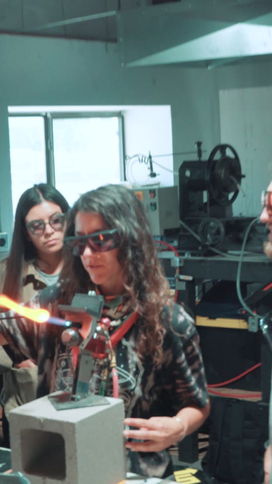 A glassblowing class, filmed around the people learning the process.